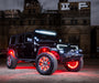 Three quarters view of black Jeep in front of a warehouse, with multiple ORACLE Lighting products installed.