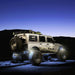 Jeep outdoors with white rock lights glowing.