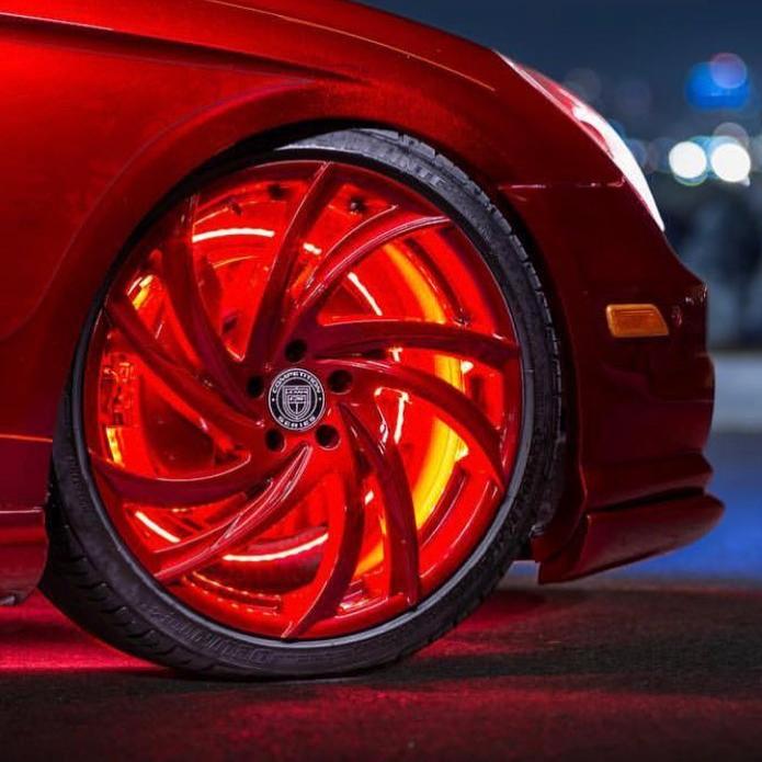 Front wheel of a red car with red LED illuminated wheel ring.