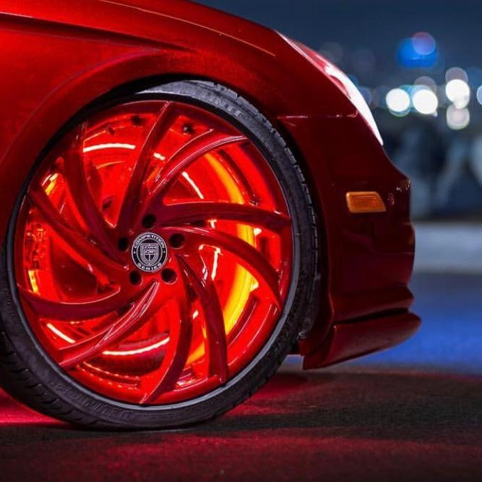 Front wheel of a red car with red LED wheel rings installed.