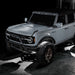 Grey Ford Bronco with multiple ORACLE Lighting products installed, but only the white rock lights are turned on.