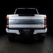 Straight rear view of a white Ford Superduty with Flush Mount Tail Lights installed and DRLs on.