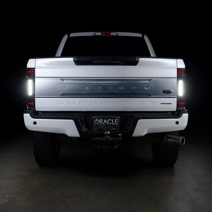 Straight rear view of a white Ford Superduty with Flush Mount Tail Lights installed and reverse lights on.