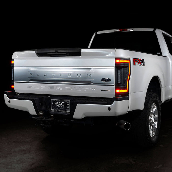 Rear three quarters view of a white Ford Superduty with Flush Mount Tail Lights installed, and DRLs on.