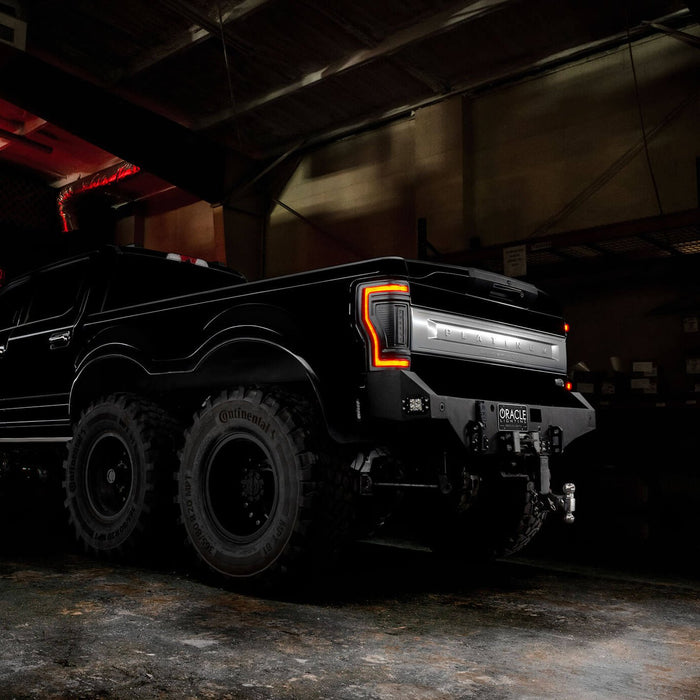 Rear three quarters view of a black Ford Superduty with Flush Mount Tail Lights installed, with DRLs on.