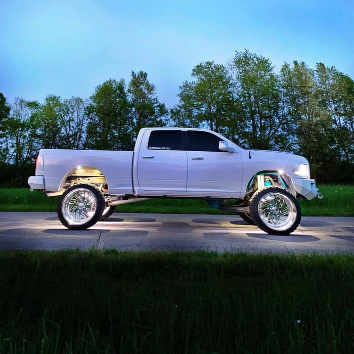 Side profile view of a white truck with white LED wheel rings.