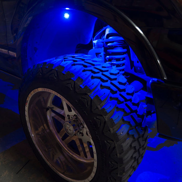 Close up of a wheel well with blue rock light glowing.