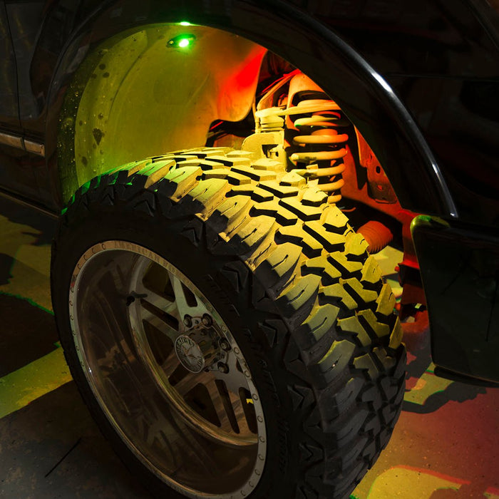 Close up of a wheel well with yellow rock light glowing.