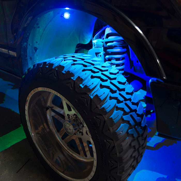 Close up of a wheel well with cyan rock lights glowing.