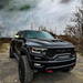 A black RAM TRX on an outdoor trail, with LED Off-Road Side Mirror Ditch Lights shining.