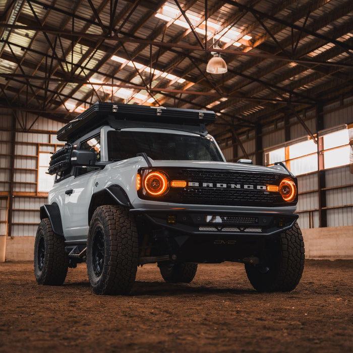 White Ford Bronco in a large barn, with amber Oculus Headlights installed.