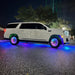 Side view of a GMC Denali with rainbow LEDs shining through the wheel wells.