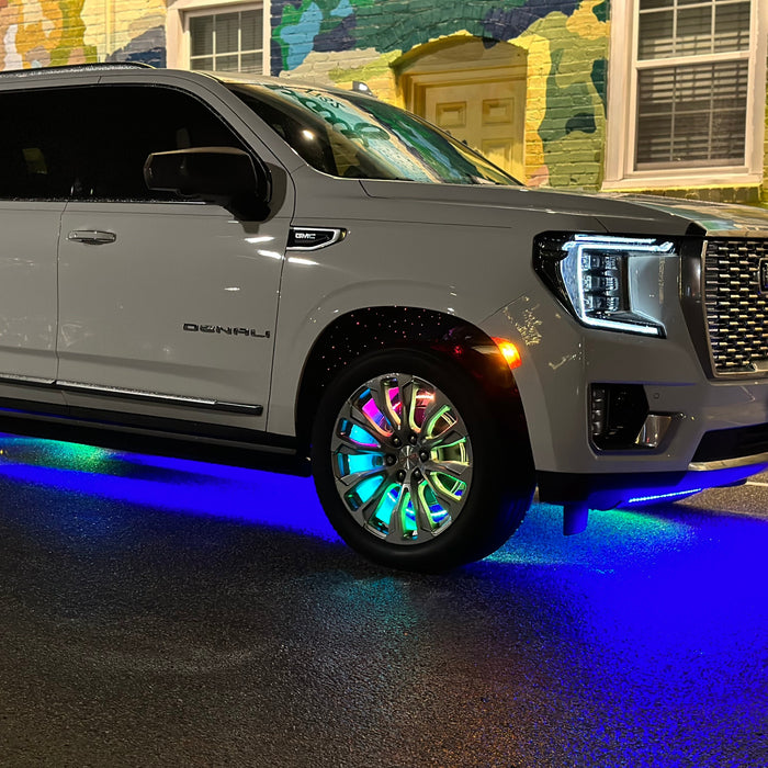 A white GMC Denali with multiple ORACLE Lighting products installed, including Dynamic Colorshift LED Wheel Rings and Fiber Optic Wheel Well Kit.