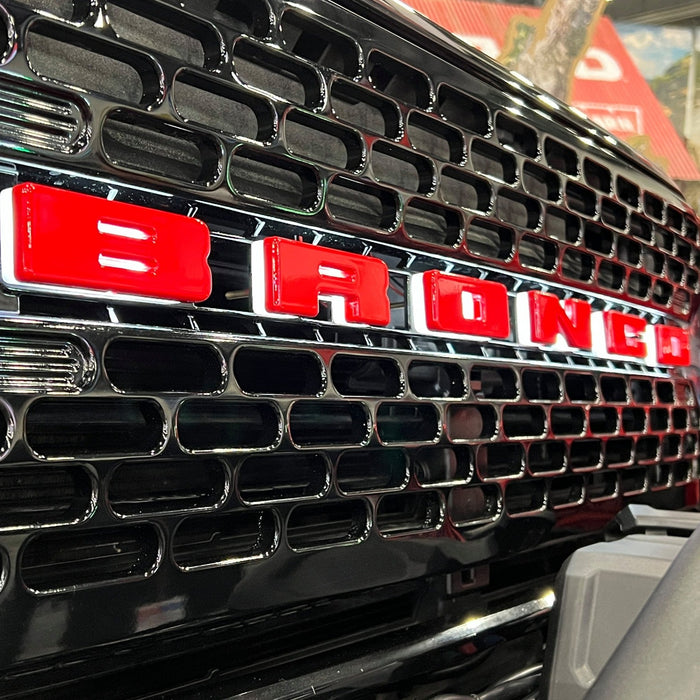 Extreme close-up on the front end of a Ford Bronco with Universal Illuminated LED Letter Badges installed.