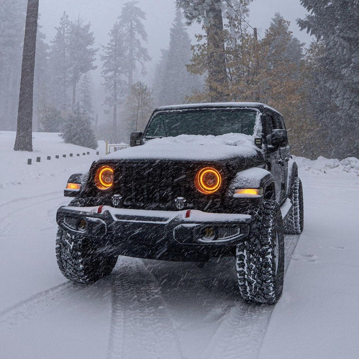 Jeep Wrangler in the snow with 7" High Powered LED Headlights installed, and amber halos on.