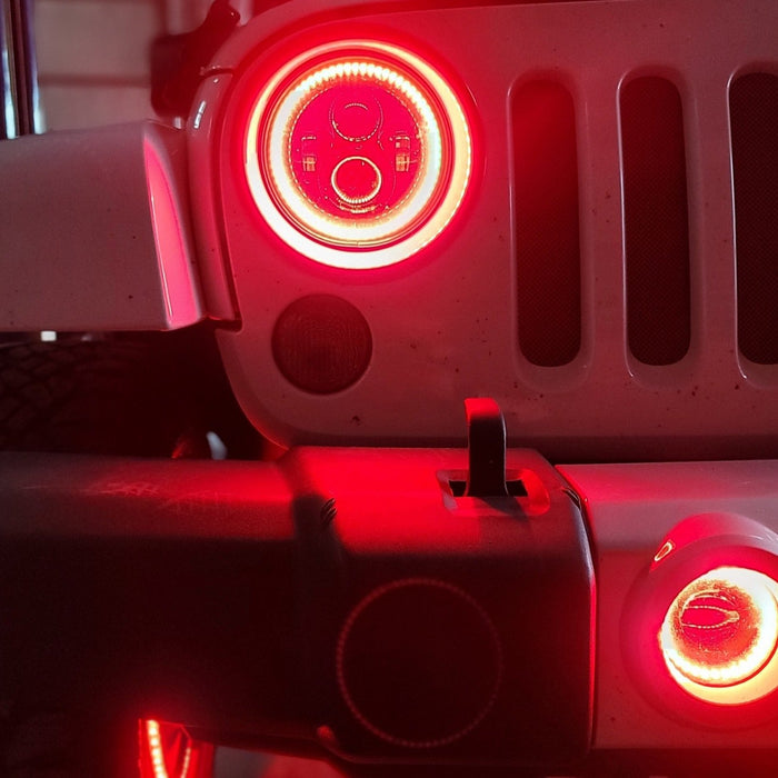 Close-up on the front end of a Jeep with High Performance 20W LED Fog Lights installed, and red halos on.