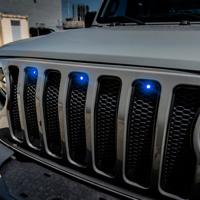 Close-up on the front end of a Jeep Wrangler with blue LED Grill Light Kit.