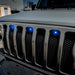 Front end of a Jeep Wrangler JL with blue Pre-Runner Style LED Grill Light Kit installed.