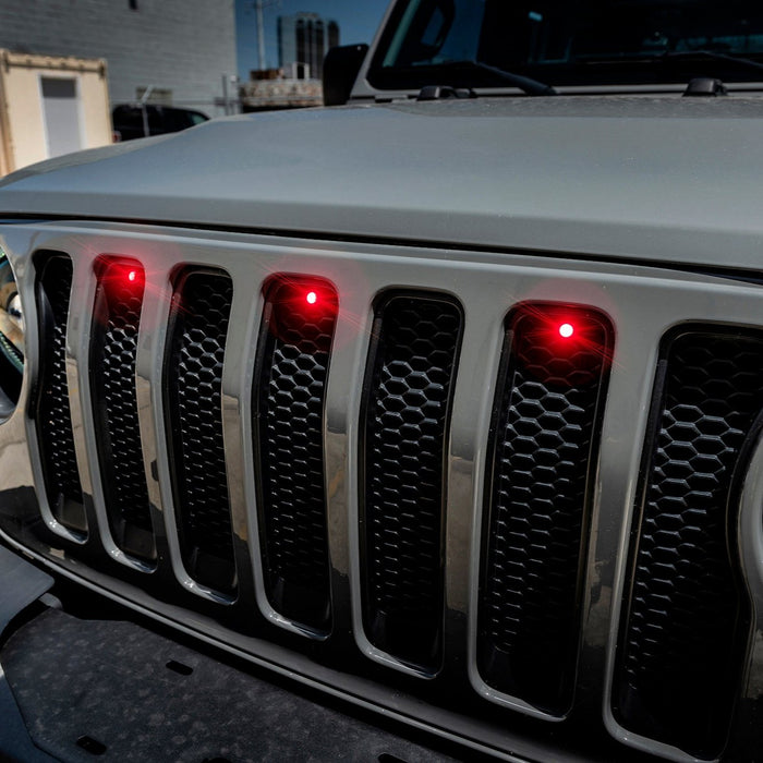 Close-up on the front end of a Jeep Wrangler with red LED Grill Light Kit.