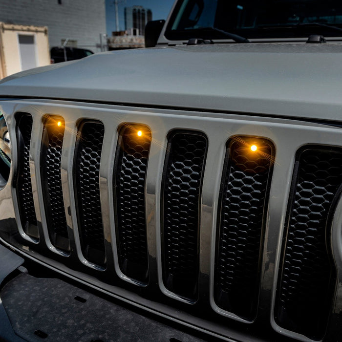 Front end of a Jeep Wrangler JL with amber Pre-Runner Style LED Grill Light Kit installed.