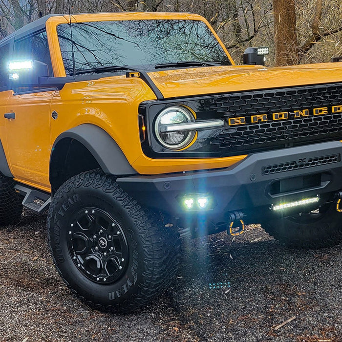 Yellow Ford Bronco riding through the woods with LED Off-Road Side Mirrors turned on.