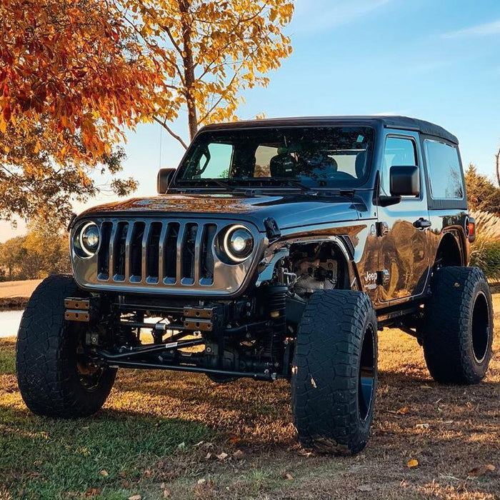 Three quarters view of a black Jeep Wrangler with Oculus Headlights installed and turned on.