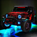 Three quarters view of a red Jeep Wrangler JL with High Performance 20W LED Fog Lights installed, and cyan halos on.