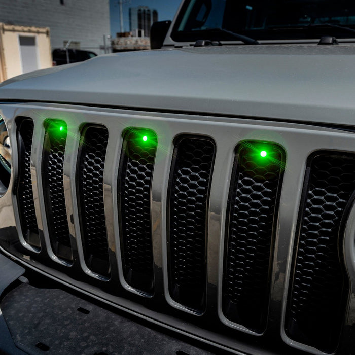 Close-up on the front end of a Jeep Wrangler with a green LED Grill Light Kit.