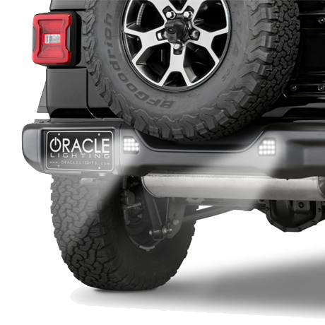 Rear end of a Jeep with ORACLE Lighting Rear Bumper LED Reverse Lights installed, and shining brightly.