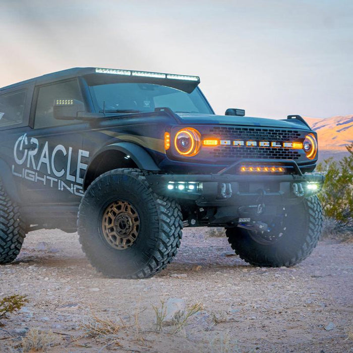 ORACLE Lighting wrapped Ford Bronco in the desert with Integrated Windshield Roof LED Light Bar System installed.