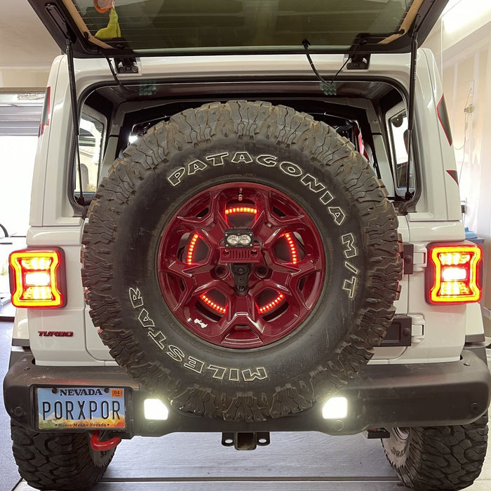 Rear end of a Jeep Wrangler JL with bright reverse lights on.