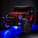 Three quarters view of a red Jeep Wrangler JL with High Performance 20W LED Fog Lights installed, and blue halos on.