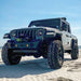 Three quarters view of a Jeep Gladiator on the beach with Oculus Headlights installed.