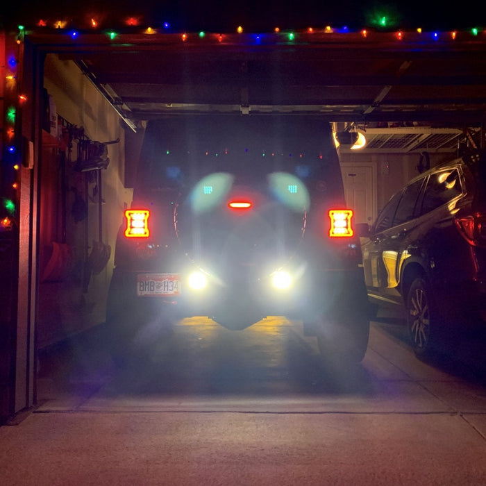 Rear end of a Jeep with bright reverse lights.